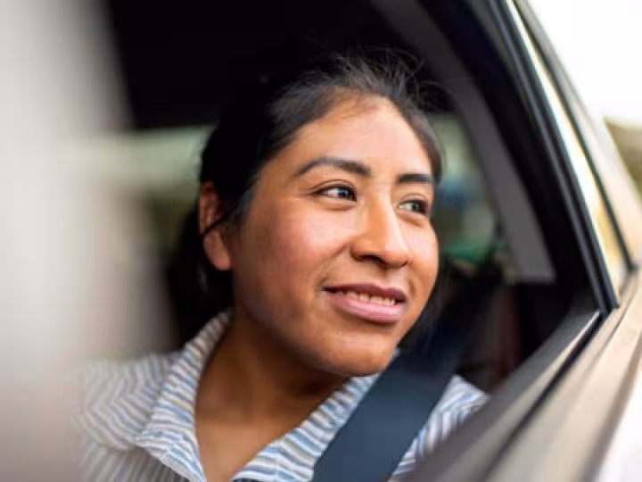 Woman smiling in the window of a car.