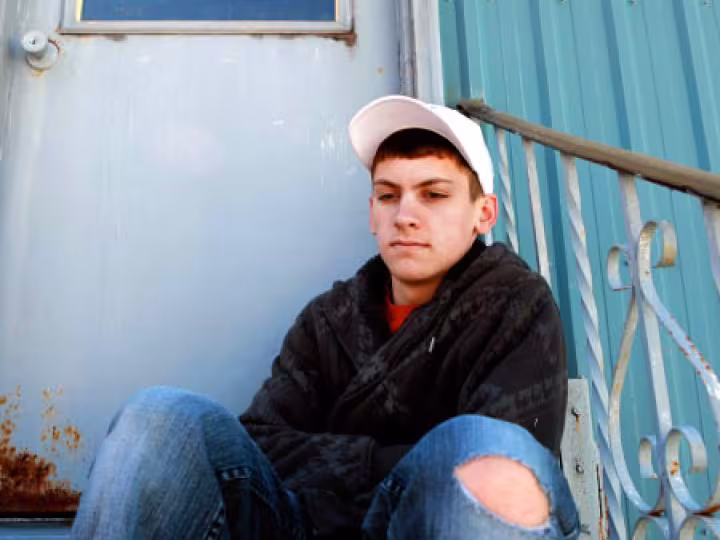 Young boy sitting with a distant look.