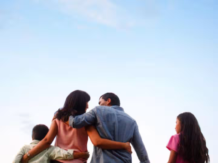 Image of a family hugging — son, mother, father, and daughter.